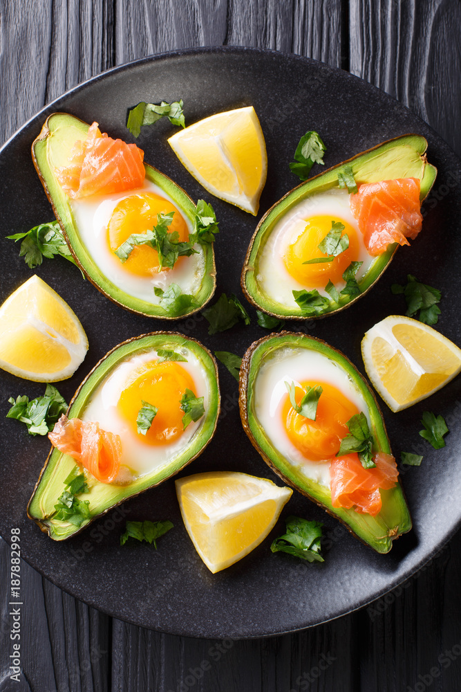 Organic baked avocado stuffed with egg and salmon closeup. Vertical top view Organic baked avocado stuffed with egg and salmon closeup. Vertical top view