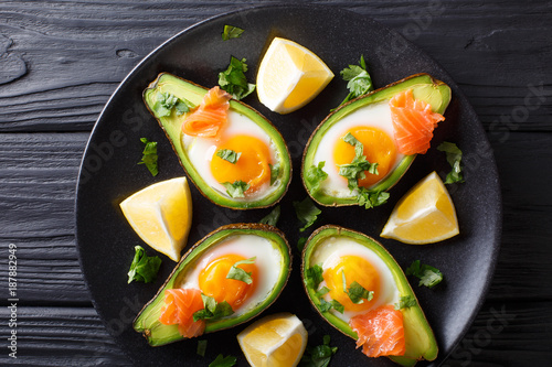 Healthy breakfast: Baked avocado with egg and salmon closeup. Horizontal top view