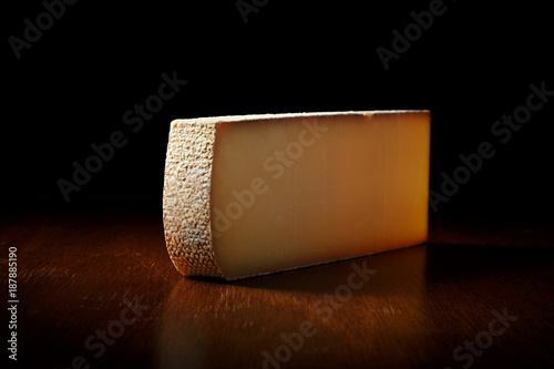 a large piece of Swiss cheese on a black background. side view. Milk product from cow's milk.