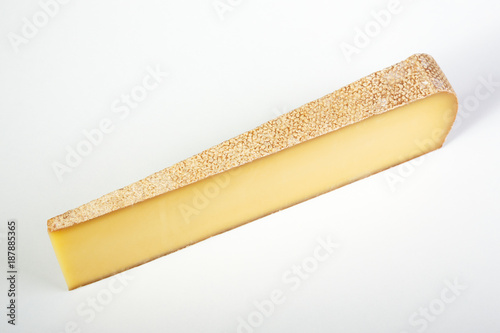 a large piece of milk cheese on a gray background