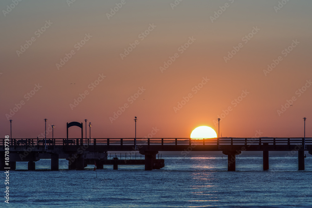 A sea bridge in the light of the rising sun. A relaxed atmosphere is reflected here again. Concept: Uralub and travel
