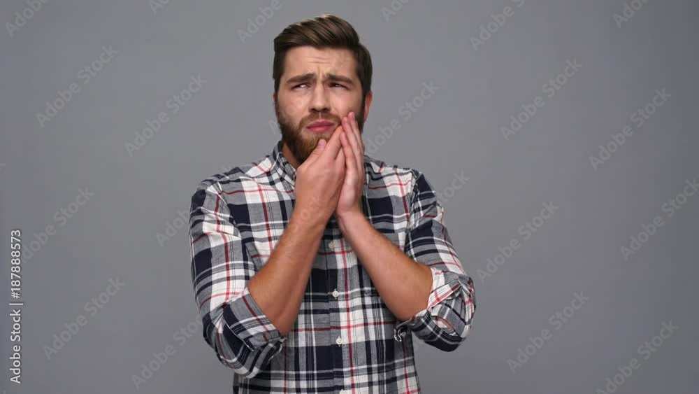 Confused bearded man in shirt having toothache and touching his cheek over gray background
Confused bearded man in shirt having toothache and touching his cheek over gray background