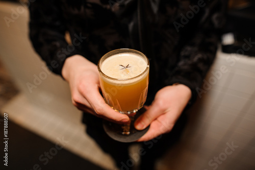 man holds a crystal glass with an alcoholic cocktail sour mix