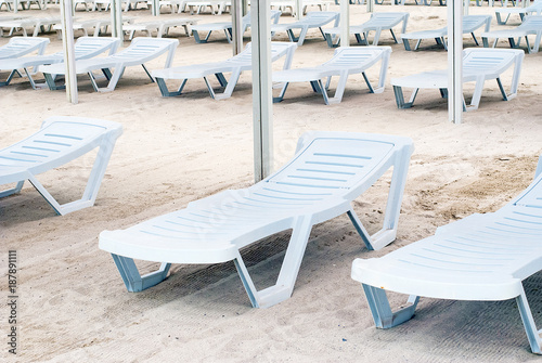 Rows of sun loungers in the sand