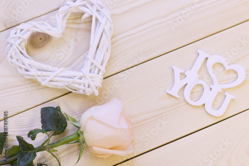 Concept of St.Valentine's Day, Love, Anniversary, Wedding with a pale cream rose, I love you inscription and decorations, natural wooden background, top view