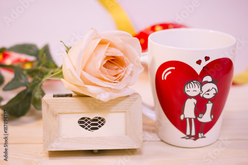 Concept of St.Valentine's Day, Love, Anniversary, Wedding with a white porcelian mug decorated with a heart image and I Love You inscription on a wooden table photo