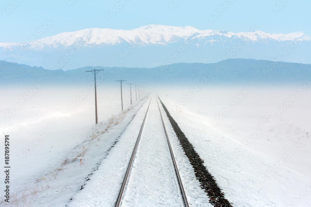 Deep Winter Train Tracks with snowy Mountains