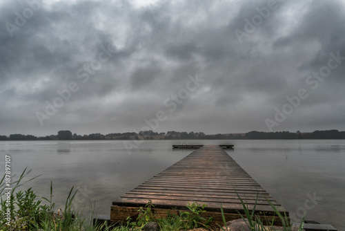 Fototapeta Naklejka Na Ścianę i Meble -  At a boat dock on a gray day. The cloudy weather beats on the mind. Concept: weather or landscape