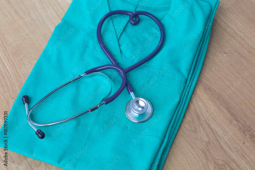 Stethoscope on a table with medical uniform Stethoscope on a table with medical uniform