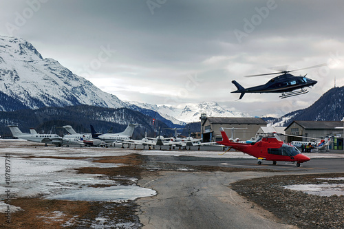 Private jets, planes and helicopters in the beautiful snow covered mountains of alps in St Moritz Switzerland