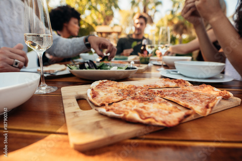 Pizza on dining table with friends