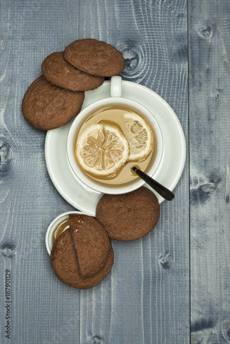 Cookies near tea on grey wooden background.