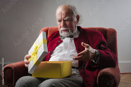 Elderly man opening a present photo