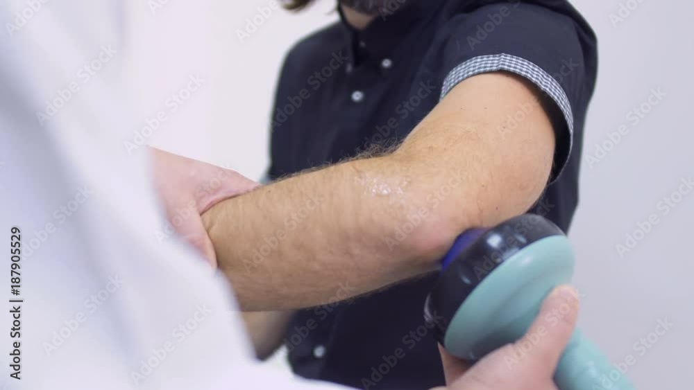 Doctor examines elbow with ultrasound equipment Doctor examines elbow with ultrasound equipment
