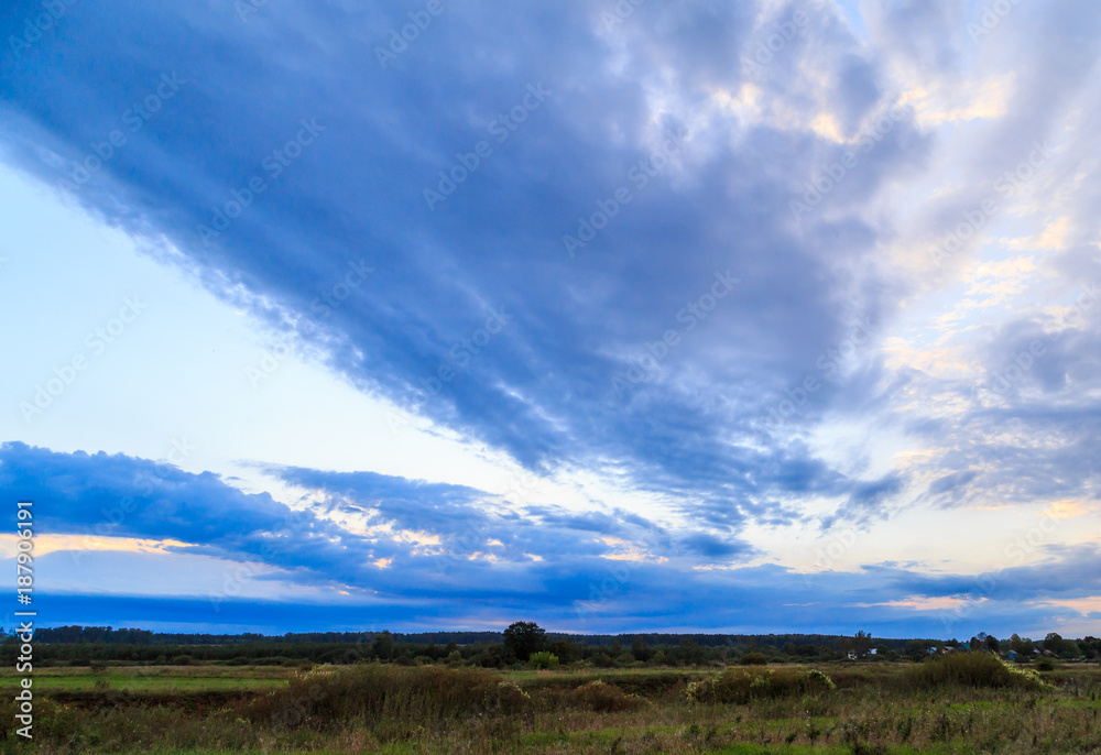 Sky with colorful clouds over a green field Sky with colorful clouds over a green field