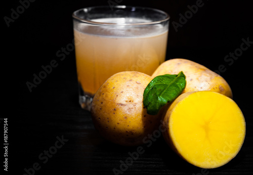 glass of potato juice on dark wooden background with copy space.