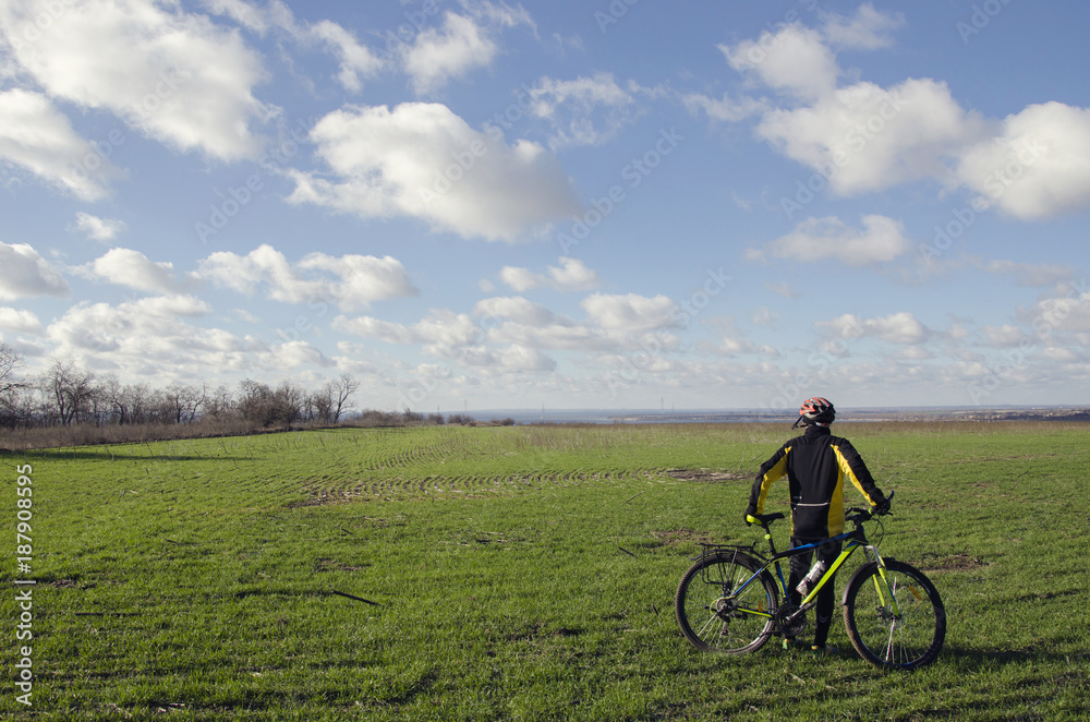 man with a bicycle on a green field