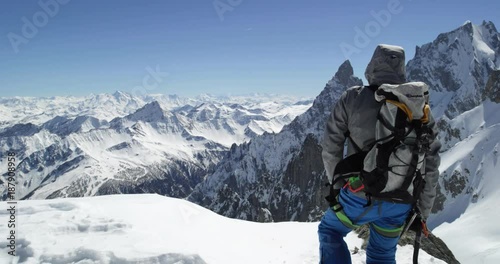 Climber mountaineer man reaching snowy mount top success in sunny day.Mountaineering ski activity. Skier people winter snow sport in alpine mountain outdoor.Back view.Slow motion 60p 4k video