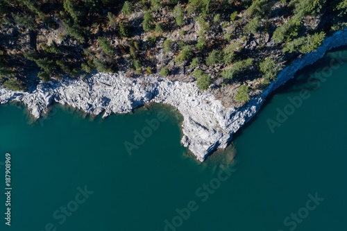 Rocky cliff and trees along the turquoise sea