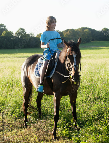 Boy in a Saddle of Horse Horseback Riding © courtyardpix