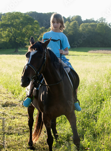 Boy in a Saddle of Horse Horseback Riding © courtyardpix