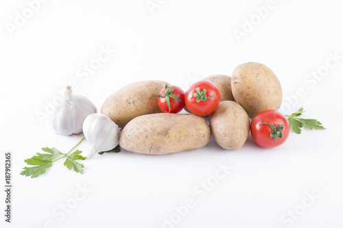 Potatoes and tomatoes on a white background. Potatoes on a white background. Red tomatoes with potatoes