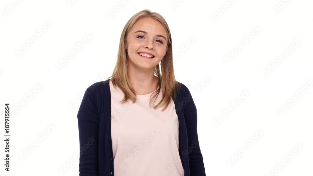 Happy blonde woman in cardigan showing thumbs up at the camera over white background Happy blonde woman in cardigan showing thumbs up at the camera over white background