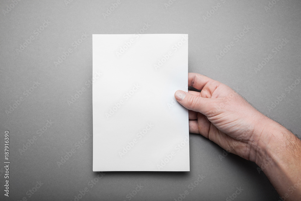 Empty Mock-up Blank catalog, magazine, book template in man hand with soft shadows on grey background for design. Empty Mock-up Blank catalog, magazine, book template in man hand with soft shadows on grey background for design.