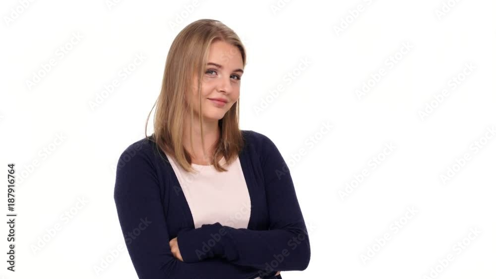 Mystery blonde woman in cardigan holding crossed arms and showing silence gesture at the camera over white background Mystery blonde woman in cardigan holding crossed arms and showing silence gesture at the camera over white background