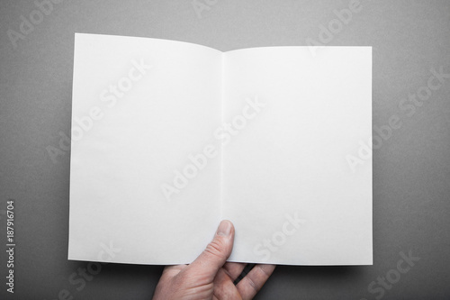 Manual start of white log with mockups of blank pages. A person reading two-page books looks at the first person.