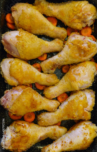 Chicken legs baked on the roasting pan in the oven.
