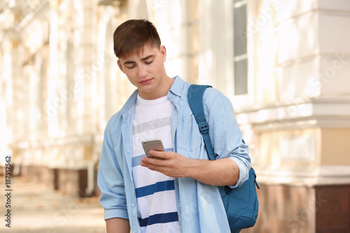 Trendy teenage boy using mo...