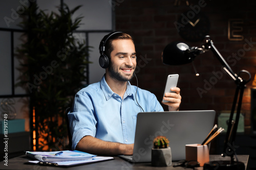 Young man with laptop and c...