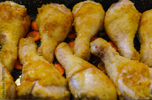 Chicken legs baked on the roasting pan in the oven.
