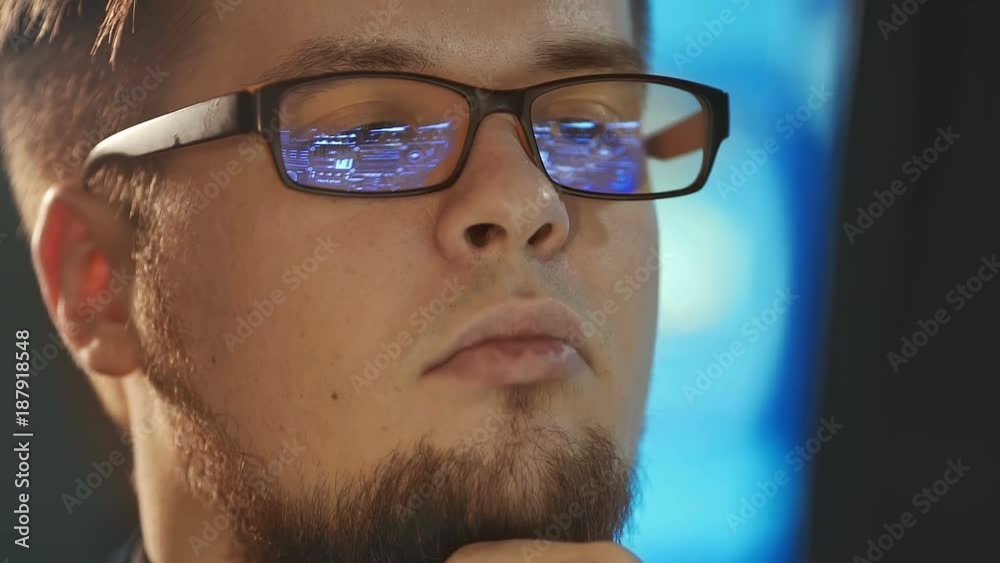 Young man working on computer in dark digital office