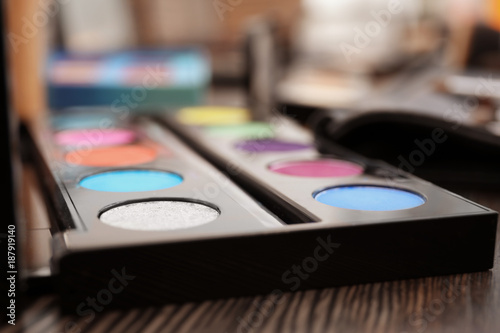 Eyeshadow palette of professional makeup artist on dressing table, closeup