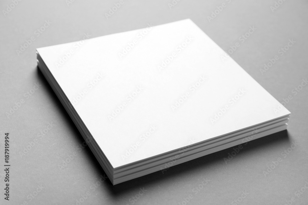 Blank sheets of paper on grey background. Mock up for design Blank sheets of paper on grey background. Mock up for design