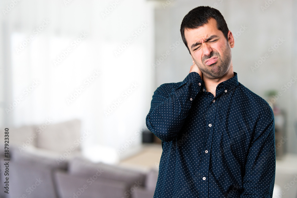 Fototapeta premium Handsome man with neck pain inside house