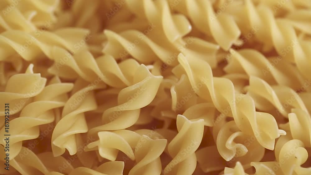 Twisted pasta from durum wheat are scattered as a background Twisted pasta from durum wheat are scattered as a background