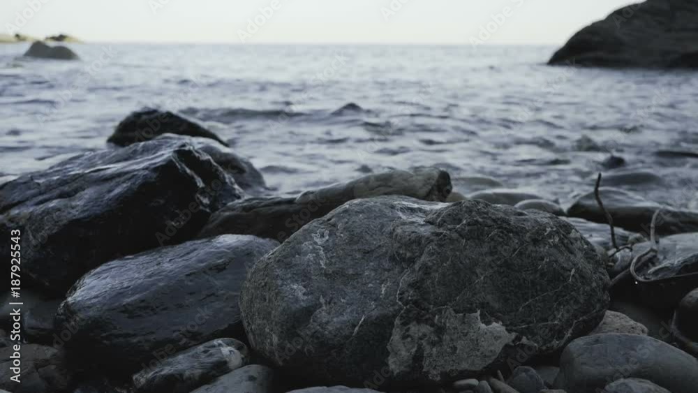 Group of shiny rocks in water, waves crashing on them. Group of shiny rocks in water, waves crashing on them.