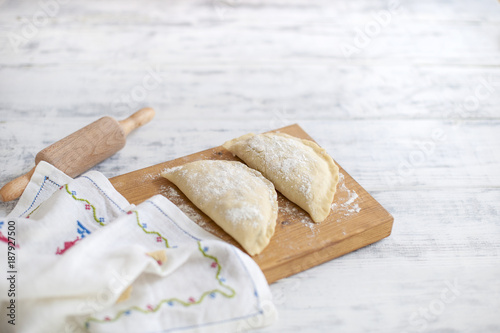 Homemade pies, cooking. Dough. A rolling pin and a towel with a pattern. Free space for text