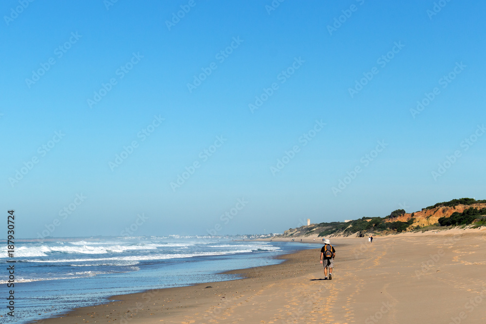 hombre caminando por la orilla de la playa