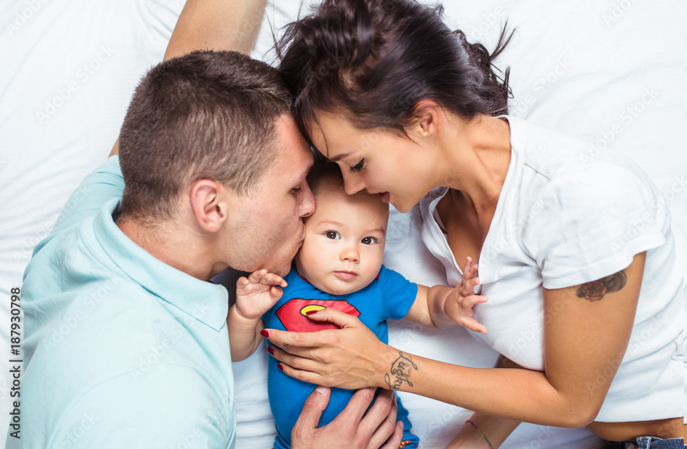 Mother and father enjoying and relaxing with their baby on bed. Mother and father enjoying and relaxing with their baby on bed.