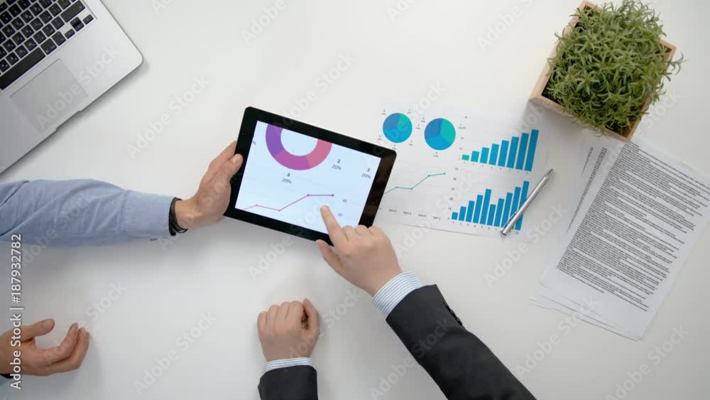 Businessmen analising diagrams in the office. View from the top of men's hands. Close-up shot. Businessmen analising diagrams in the office. View from the top of men's hands. Close-up shot.