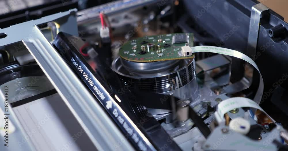 A closeup inside view of the electronics of a VCR as a VHS tape is inserted and ejected. Top off view. With audio. A closeup inside view of the electronics of a VCR as a VHS tape is inserted and ejected. Top off view. With audio.