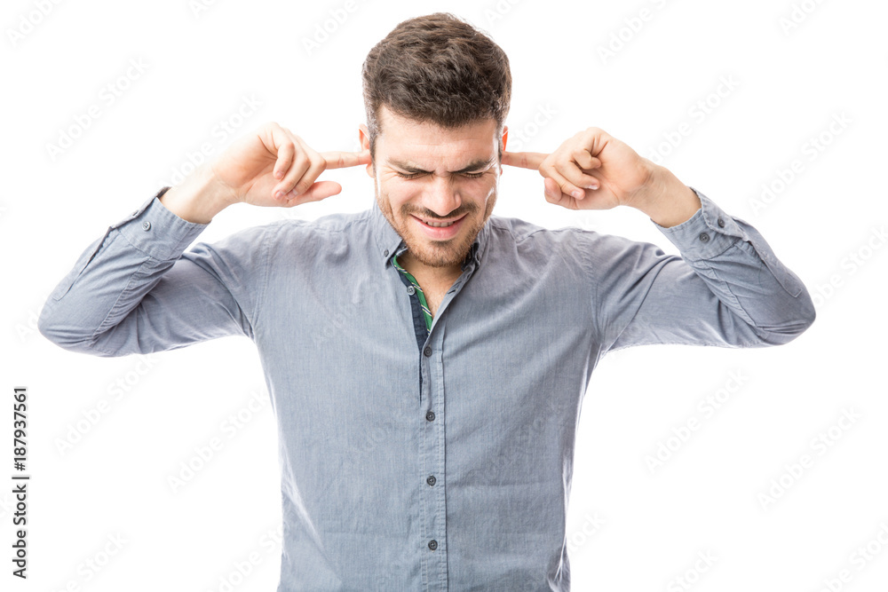 Hispanic man covering his ears because of some noise Hispanic man covering his ears because of some noise