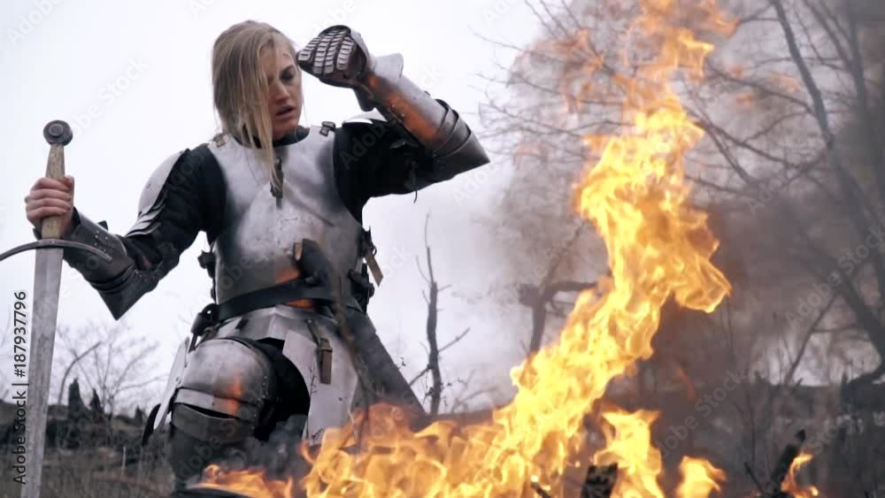 Wounded Jeanne d'Arc is kneeling by the fire Wounded Jeanne d'Arc is kneeling by the fire