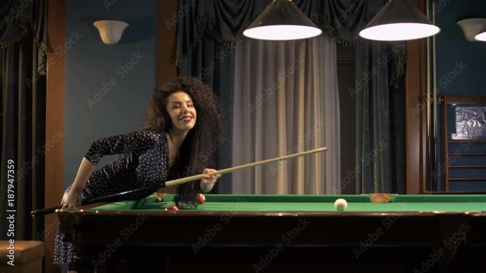 Beautiful woman in black dress play billiard