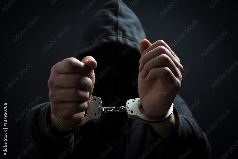 The killer with handcuffs in the dark. Arrested by the police The killer with handcuffs in the dark. Arrested by the police