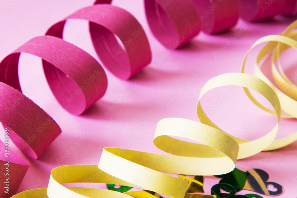 Party decoration. colorful streamers on pink background.